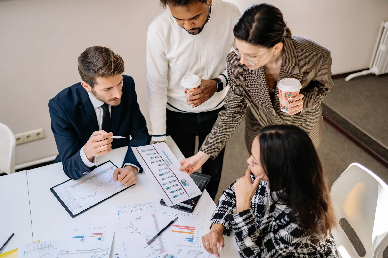 Four colleagues discuss data and strategy in an office setting. Ecommerce marketing strategy development: a process