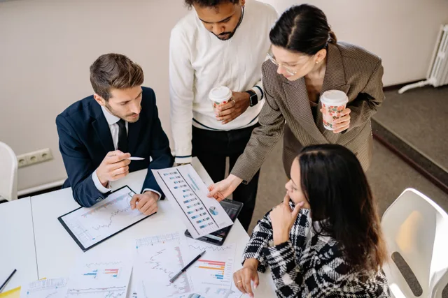 Four colleagues discuss data and strategy in an office setting. Ecommerce marketing strategy development: a process