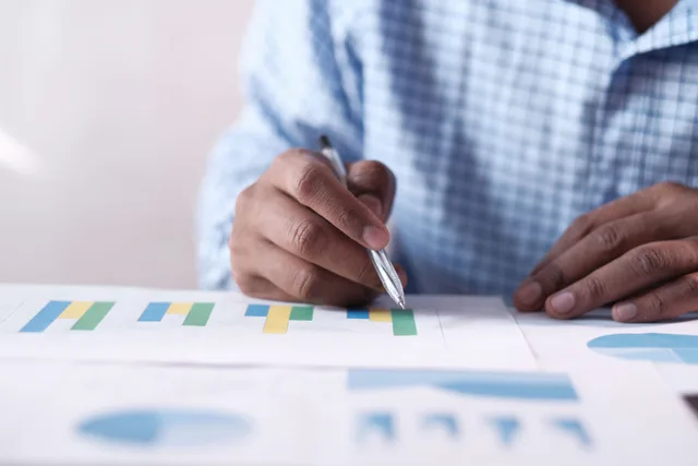 Close-up of hands analyzing colorful graphs, indicating business planning. Three ecommerce marketing strategy examples with worked economics