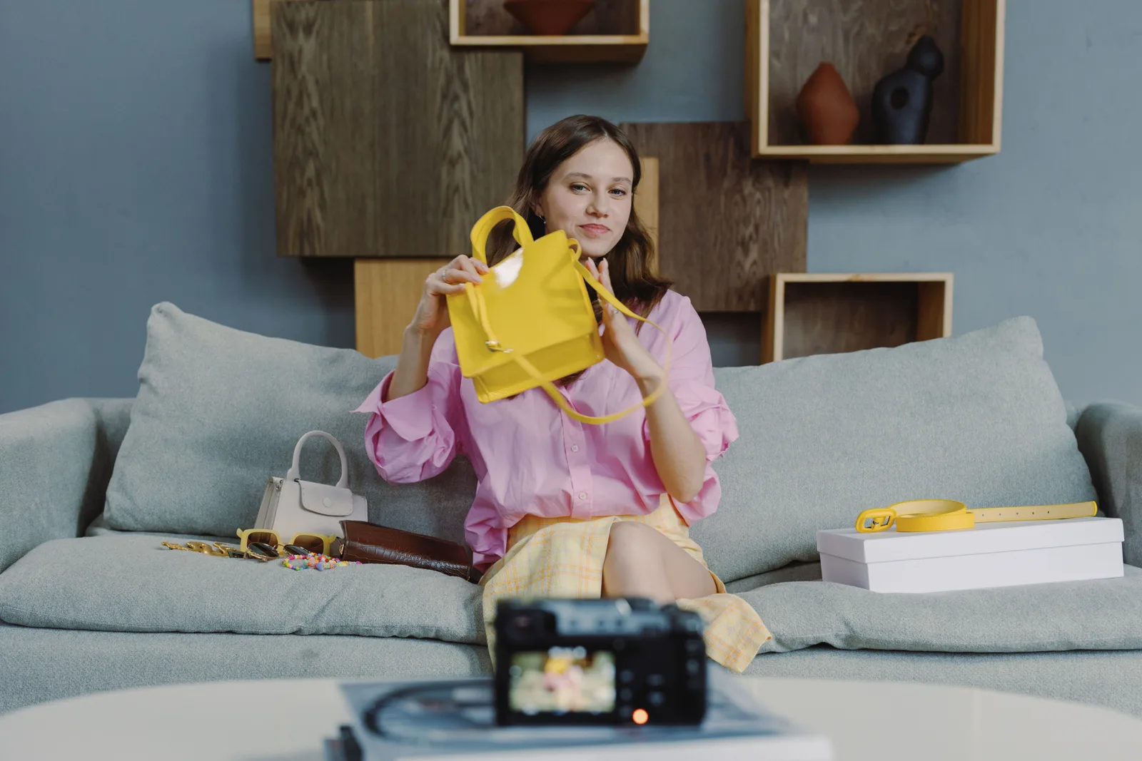 A young woman showcasing a yellow handbag during a live online fashion sale session. 3 parts of ecommerce marketing strategy trends, explained