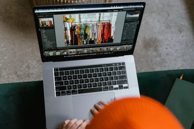 A person in a cozy setting edits photos of clothing displays on a laptop. Ecommerce SEO best practices for filter and variant URLs